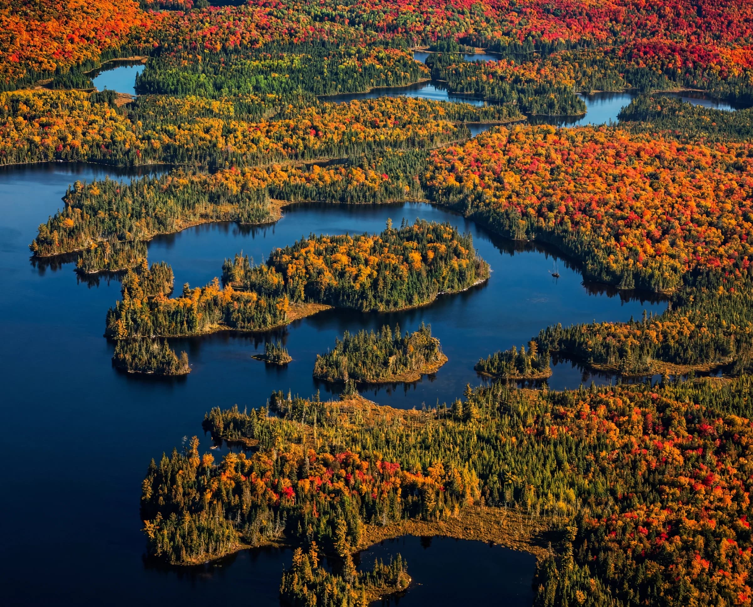 Aerial view of autumn forest and island-strewn lakes at Méchante Cabane