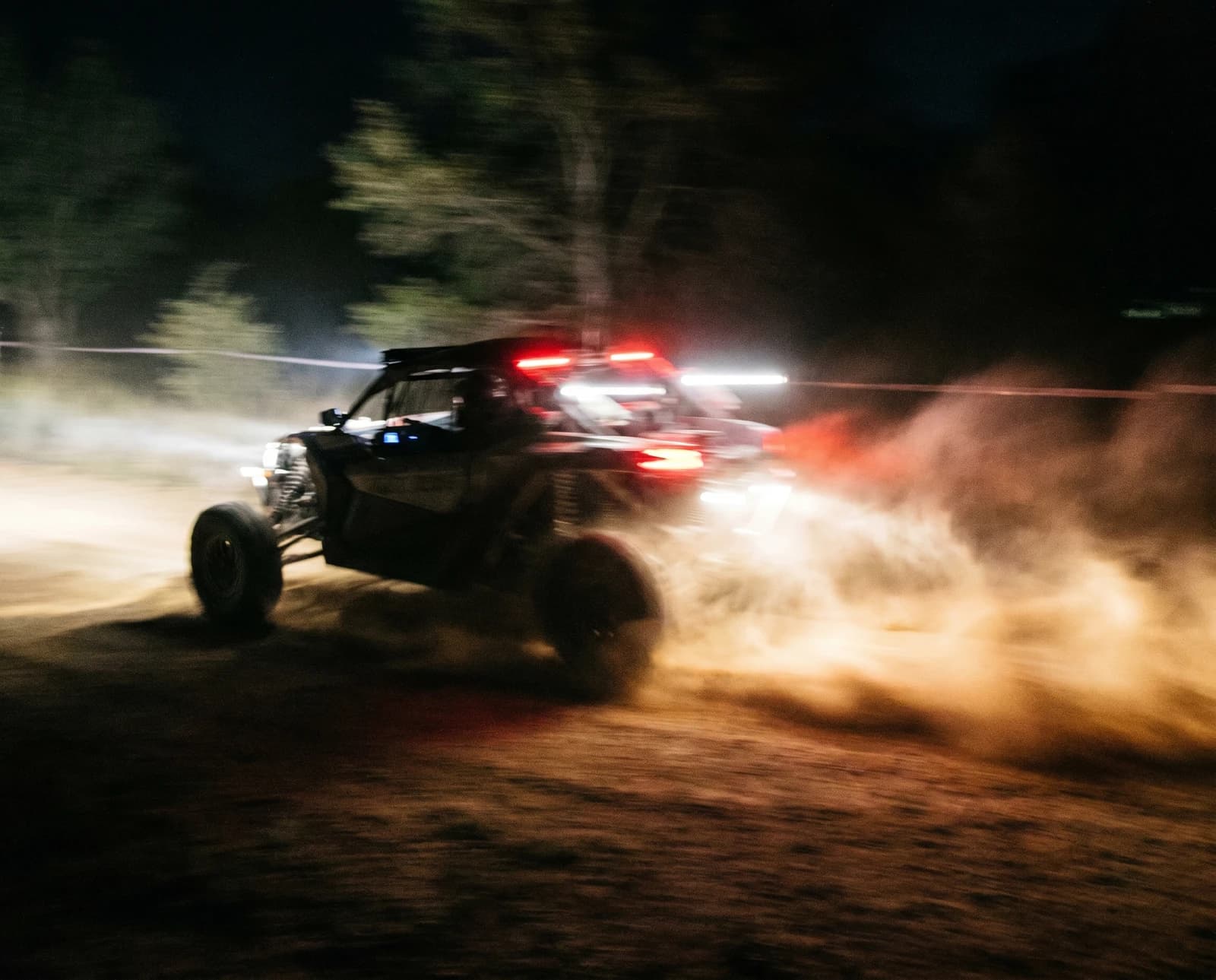 Side-by-side buggy racing down a dirt trail
