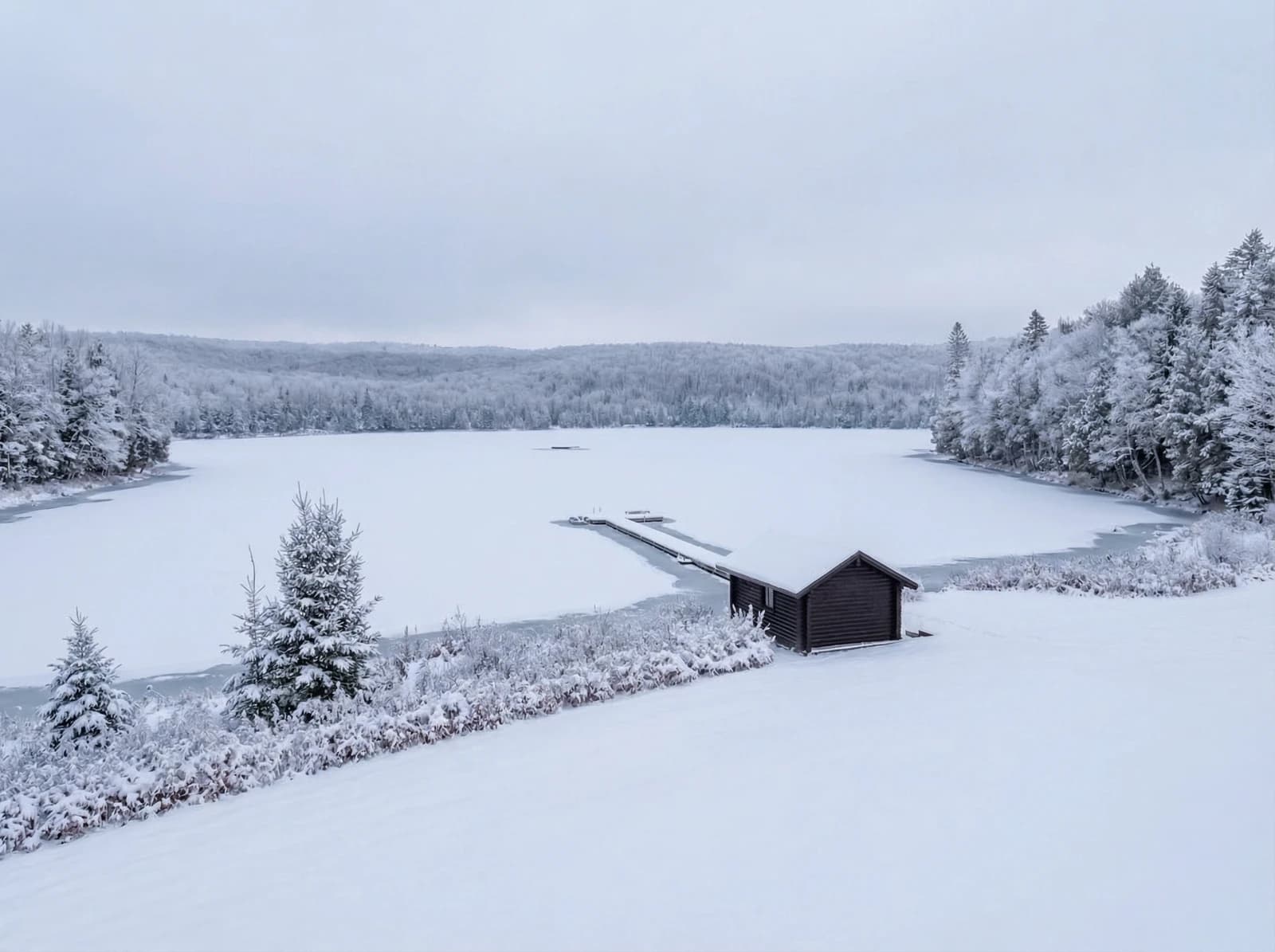 Snow-covered dock reaching into the frozen lake