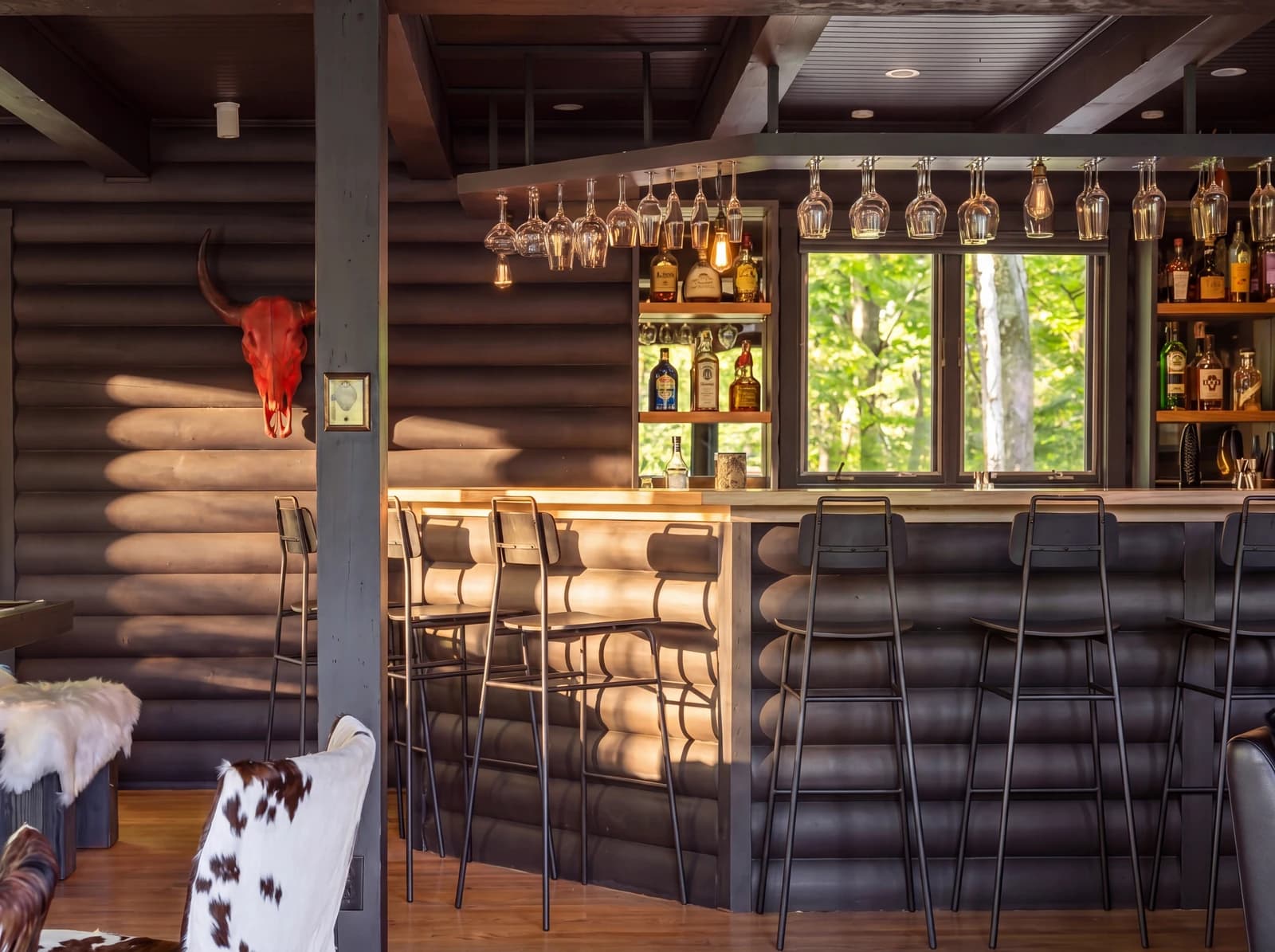 Rustic log bar with stools and bottles