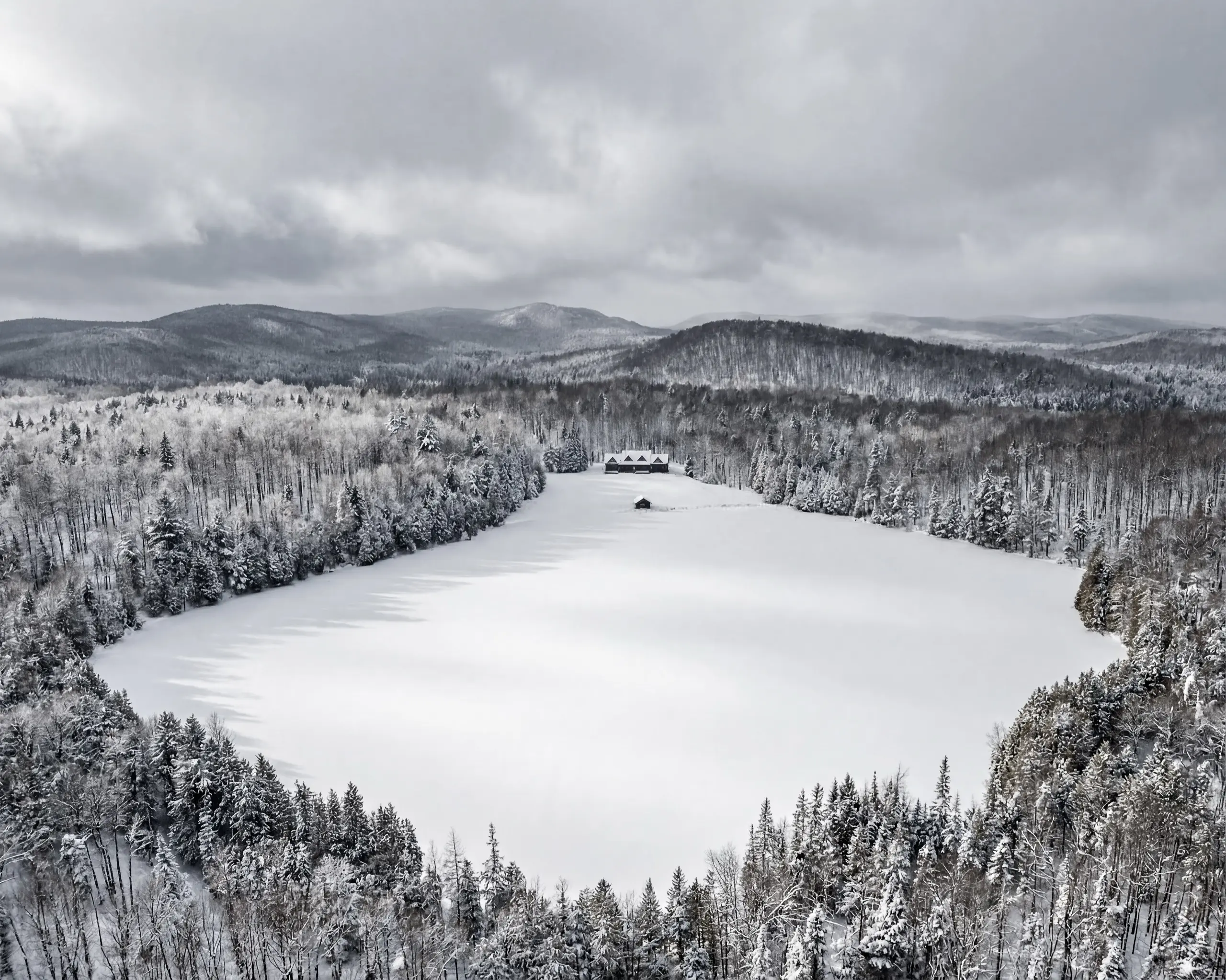 Méchante Cabane — winter aerial view of the chalet and frozen lake